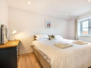 a bedroom with a large white bed and a television at River View in Trimingham