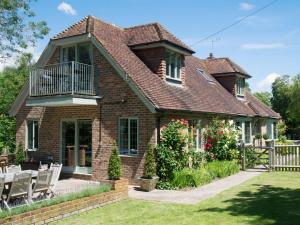 a brick house with a balcony on top of it at Twisly North Lodge in Catsfield