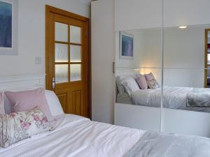 una camera da letto con specchio a parete di The Tranquil Orchard - Woodpecker-uk31339 a Mouswald