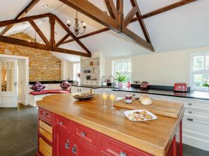 a large kitchen with wooden counter tops and wooden beams at Allerton House in Isham