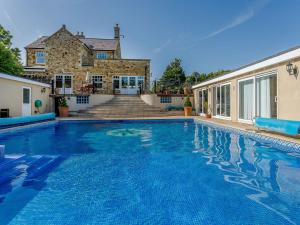 a swimming pool in front of a house at Allerton House in Isham