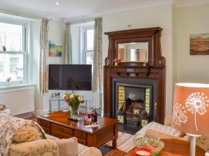 a living room with a fireplace and a tv at Forge Villa in Ebberston