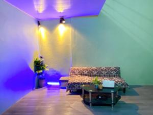 a room with a couch and a table and purple lights at Cúc cu Homestay 3 in Kiến An