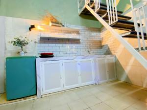 a kitchen with white cabinets and a staircase at Cúc cu Homestay 3 in Kiến An