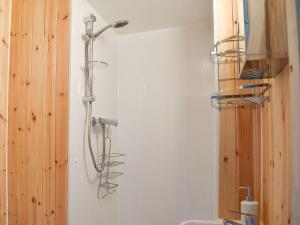 a shower in a bathroom next to a wall at Skipton Shepherds Hut - Dales View in Cononley