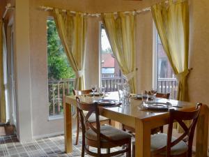 a dining room with a table and chairs and a window at Lodge A- Uk33088 in Dinnet