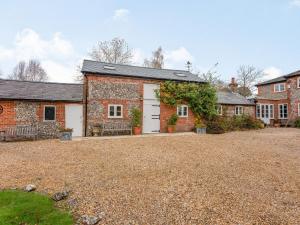 an old brick house with a white garage at The Stables At Wells-in-the-field Farm in Whitchurch