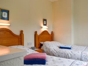 1 Schlafzimmer mit 2 Betten und 2 Lampen an der Wand in der Unterkunft Honeybags-uk12422 in Widecombe in the Moor