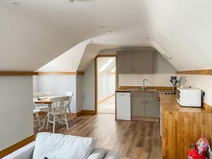 a kitchen and living room with a couch and a table at The Oaks - Uk33998 in Child Okeford