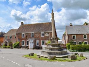 an old brick building with a clock tower in front of it at The Oaks - Uk33998 in Child Okeford