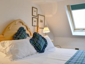 a bedroom with a bed with blue and white pillows at Fearnmore Church in Fearnmore