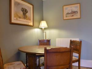 a dining room table with chairs and a lamp on the wall at Dusty House in Ashbourne