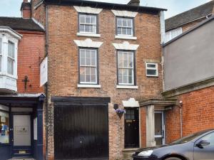 a red brick house with a black garage at Dusty House in Ashbourne