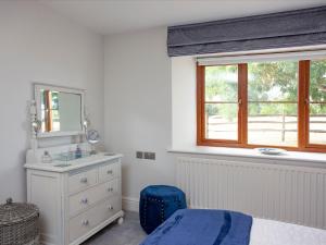 1 dormitorio con cama, lavabo y espejo en The Linhay en Durleigh