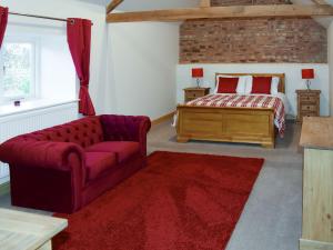 a living room with a bed and a couch and a bed at Grange Cottage in Nawton