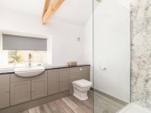 a bathroom with a toilet and a sink and a shower at Grange Cottage in Nawton