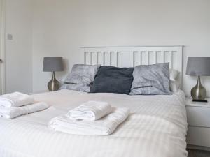 Una cama blanca con dos toallas encima. en Caddie - Uk11038 en Carlyon Bay
