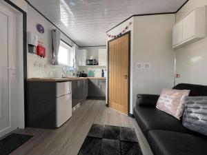 a living room with a couch and a kitchen at Uist - Uk34049 in Stornoway