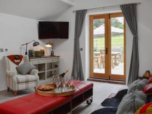 a living room with a table with wine glasses on it at Black Lion Folly in Rhydymwyn