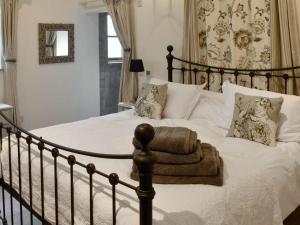 una camera da letto con letto, lenzuola e cuscini bianchi di Black Lion Folly a Rhydymwyn