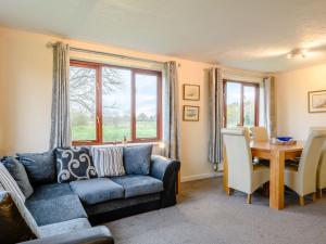 a living room with a couch and a table at Riverside Cottage in Loddon