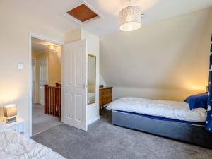 a bedroom with a bed and a mirror at Riverside Cottage in Loddon