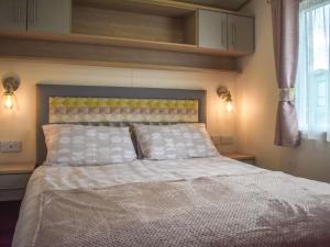a bed with white sheets and pillows in a bedroom at The Endeavour - Uk37771 in Stoupe Brow