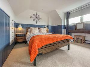 a bedroom with a large bed with an orange blanket at Iseabails House in Balintore