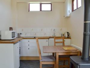 a kitchen with a wooden table and a microwave at Borran Annexe in Colton