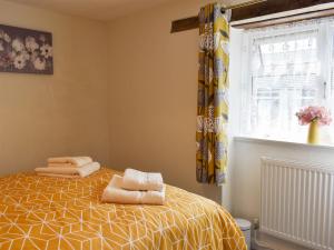 1 dormitorio con 1 cama con toallas en The Dairy Barn, en Burlescombe