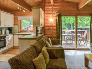 a living room with a couch and a kitchen at Red Kite Lodge - Uk37417 in Legbourne