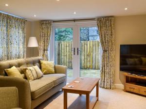 a living room with a couch and a television at May Cottage - Uk12970 in Settle