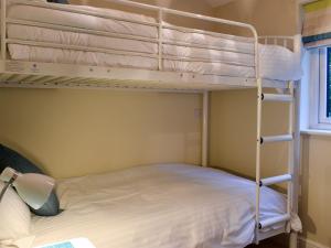 a bedroom with two bunk beds and a window at May Cottage - Uk12970 in Settle