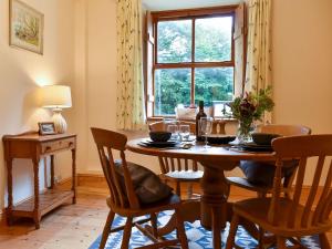 een eetkamer met een tafel en stoelen en een raam bij Bell Hill Cottage in Lindale