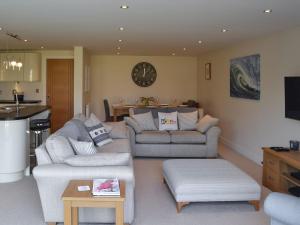 a living room with two couches and a kitchen at Quay House in Burton