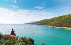 a large body of water with people swimming in it at Beautiful Apartment In Rabac With House Sea View in Raša