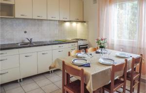 a kitchen with a table with chairs and a table cloth on it at Beautiful Apartment In Rabac With House Sea View in Raša