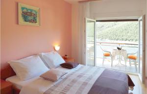 a bedroom with a bed with a view of a balcony at Beautiful Apartment In Rabac With House Sea View in Raša