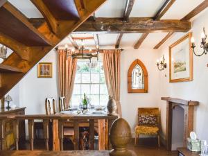 uma sala de jantar com uma mesa e uma janela em Canons Hall Cottage em Wingham