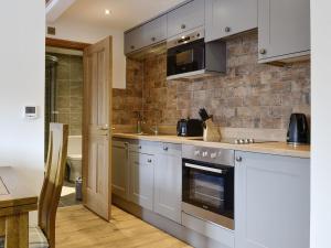 a kitchen with gray cabinets and a counter top at The Byres Tethera in St Bees