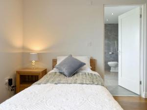 a bedroom with a bed and a bathroom with a toilet at Miners Meadow 