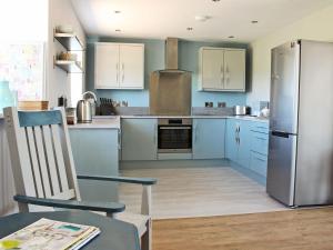 a kitchen with blue cabinets and a stainless steel refrigerator at Pasture View in Barnard Castle
