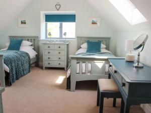 a bedroom with two beds and a desk and a mirror at Pasture View in Barnard Castle