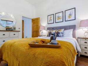 a bed with a tray with two teddy bears on it at Little Orchard in Worlington