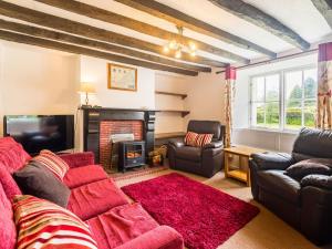 a living room with a couch and a fireplace at Well Farmhouse - Uk11880 in North Tamerton