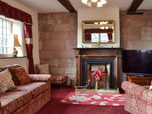 a living room with a fireplace and a tv at Dairy House Farm in Horton