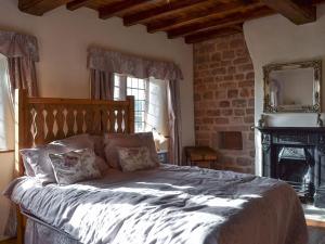 a bedroom with a bed in a room with a fireplace at Dairy House Farm in Horton