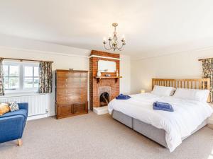 een slaapkamer met een groot bed en een open haard bij Mark Farmhouse in Bradwell on Sea