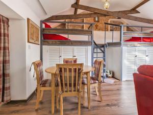 ein Esszimmer mit einem Tisch, Stühlen und einem Etagenbett in der Unterkunft The Little House In Hull in Hull
