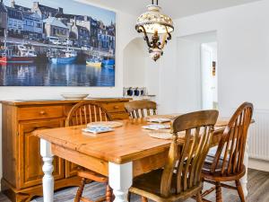 a dining room with a wooden table and chairs at Needle Cottage in Cullen